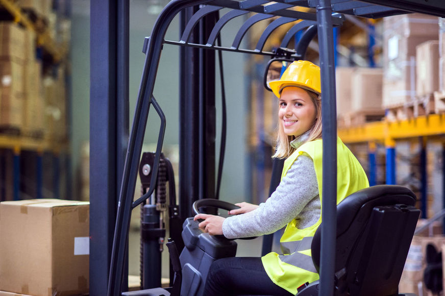 Woman warehouse worker with forklift